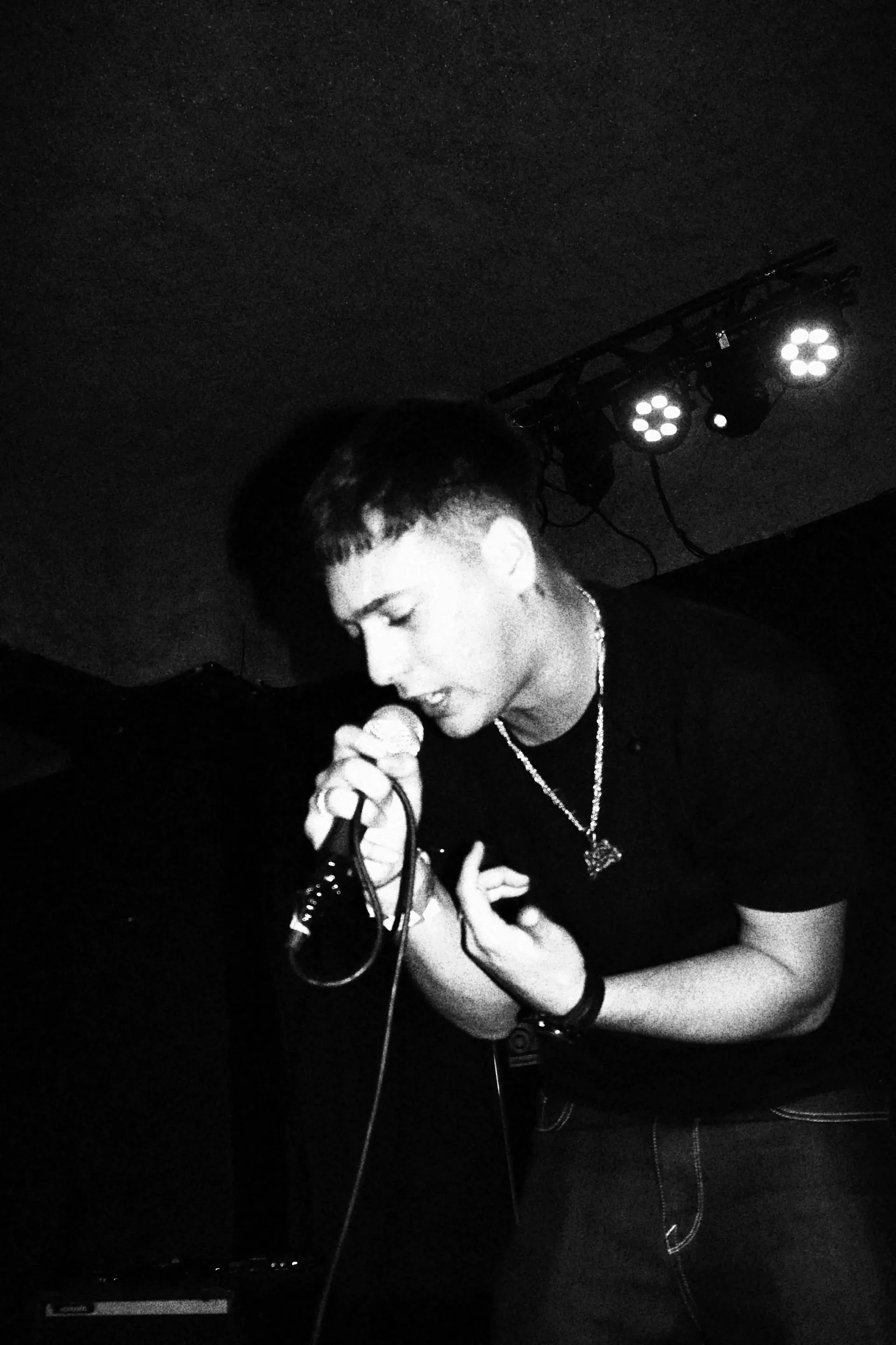 Cantante con micrófono durante un show en vivo, blanco y negro — cobertura de recital