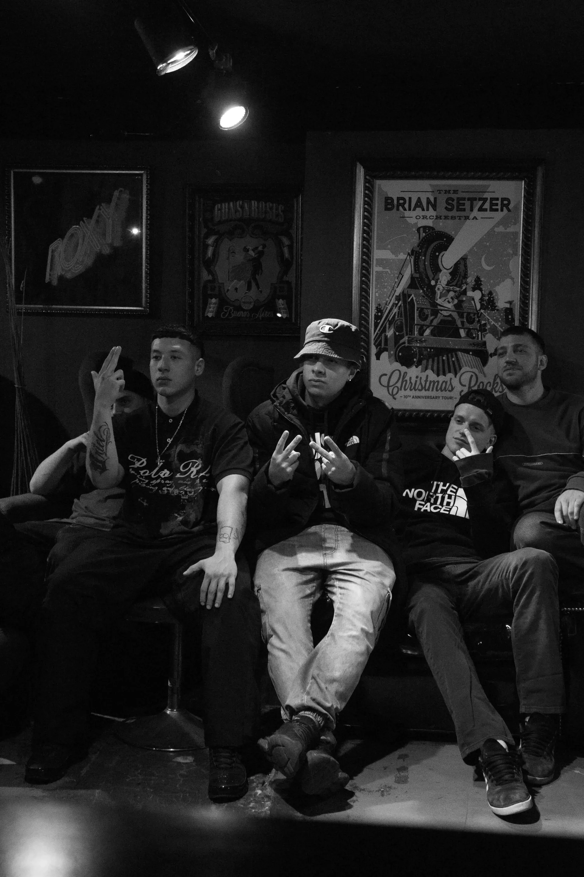 Grupo de amigos posando en un sillón dentro de un bar, blanco y negro