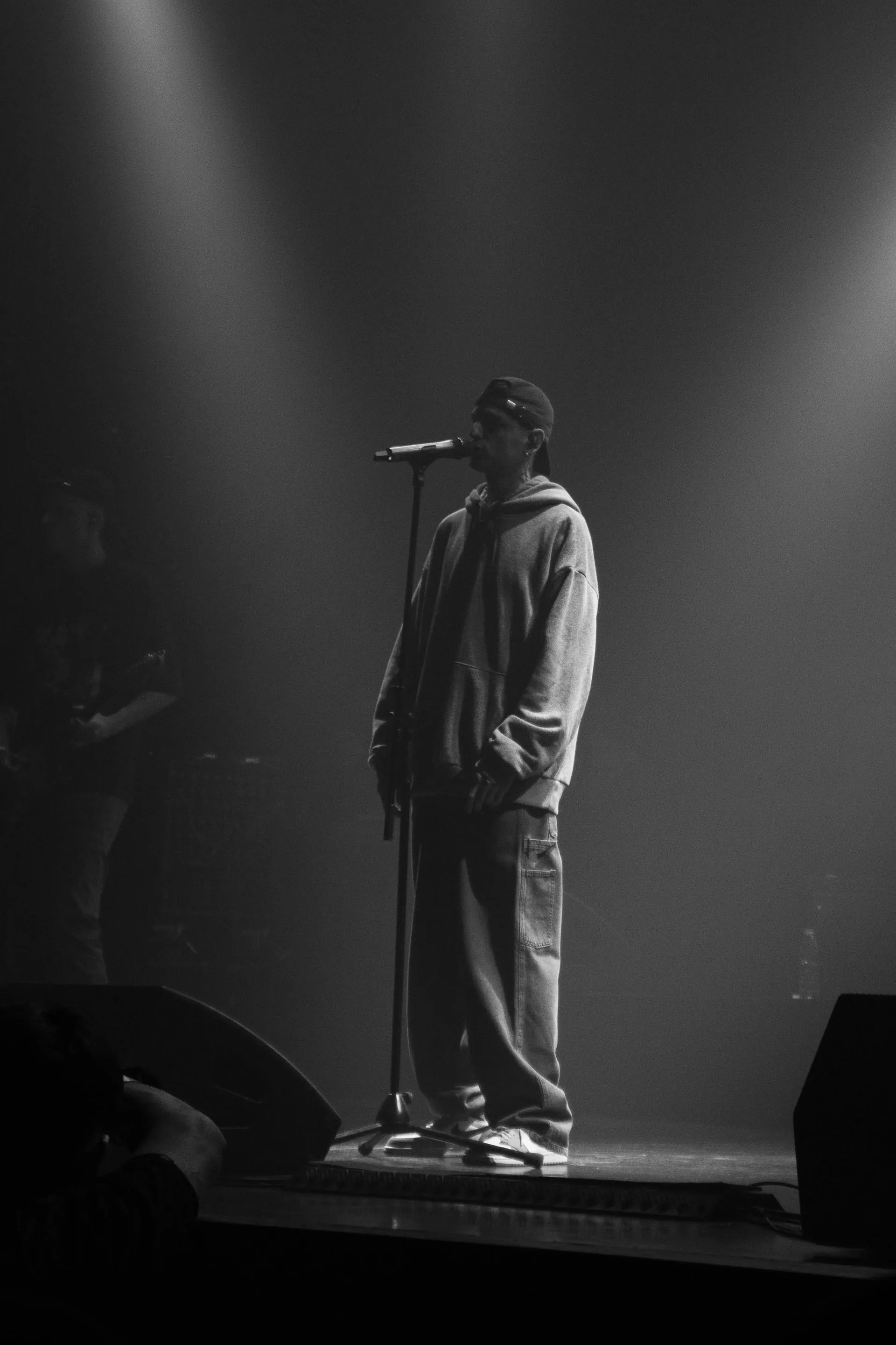 Cantante solo en el escenario bajo un haz de luz cenital, blanco y negro