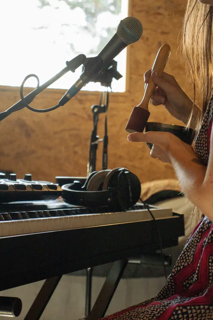 Música frente a su teclado y micrófono durante un ensayo