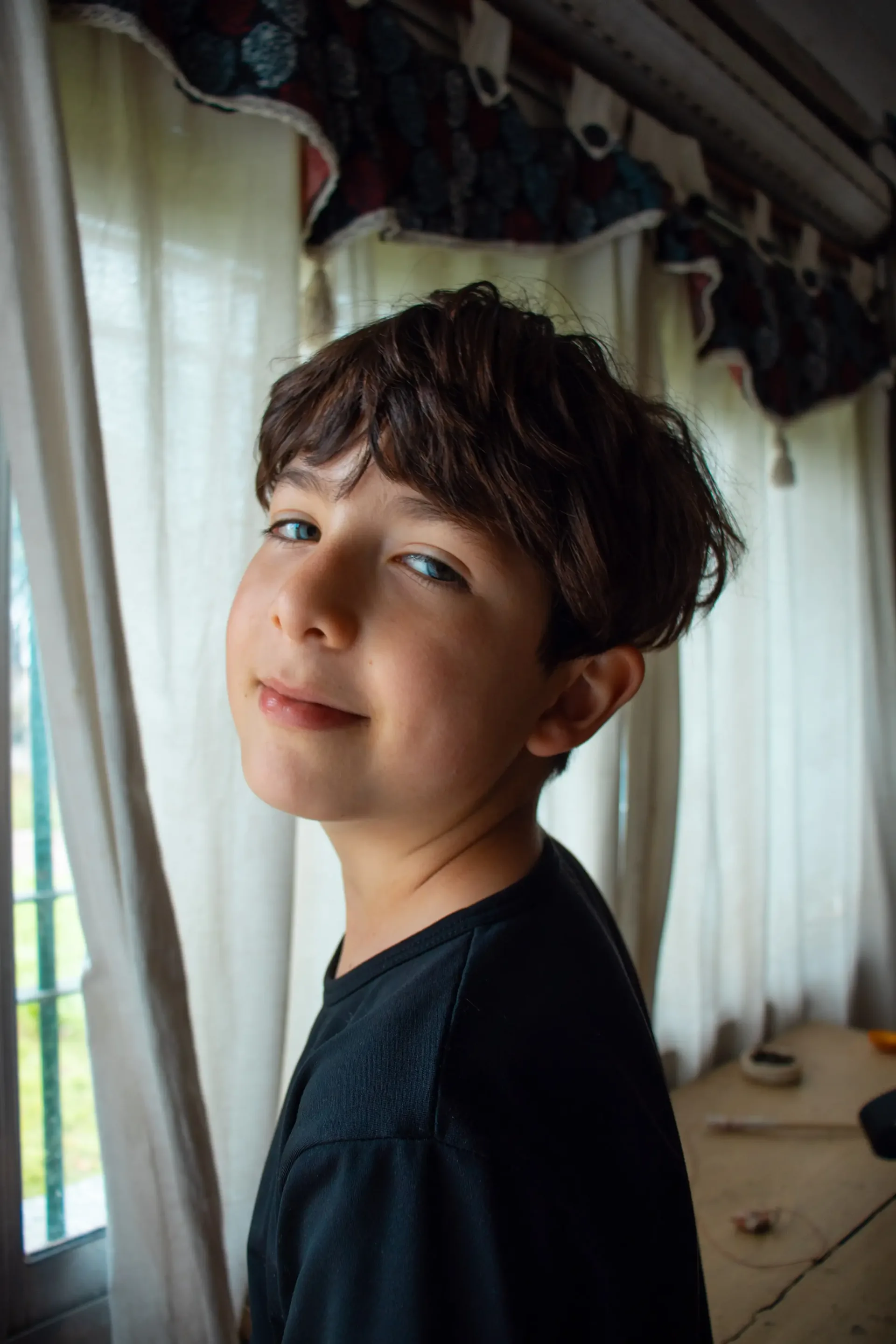 Retrato de un chico junto a la ventana con luz natural