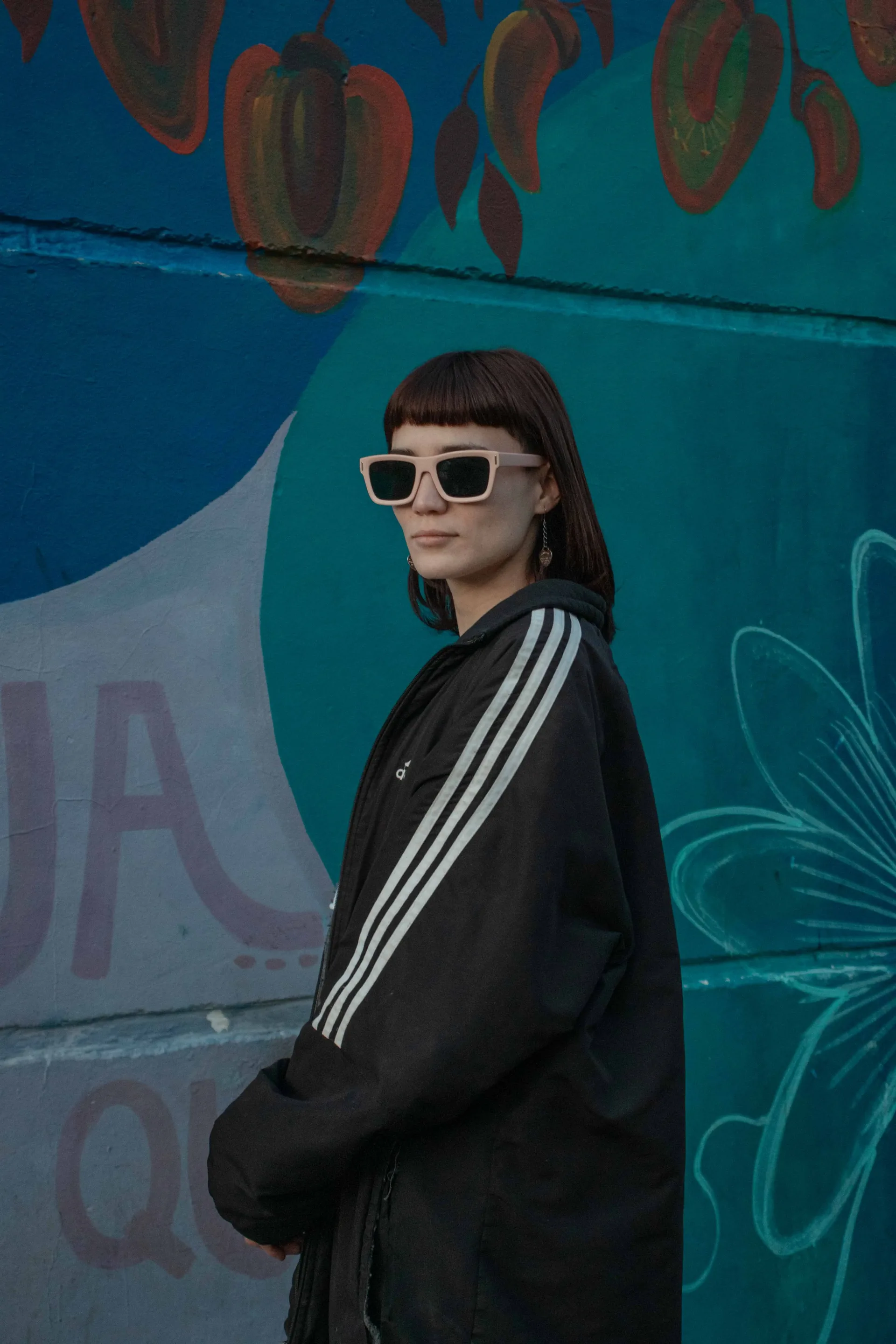 Retrato de perfil frente a un mural turquesa
